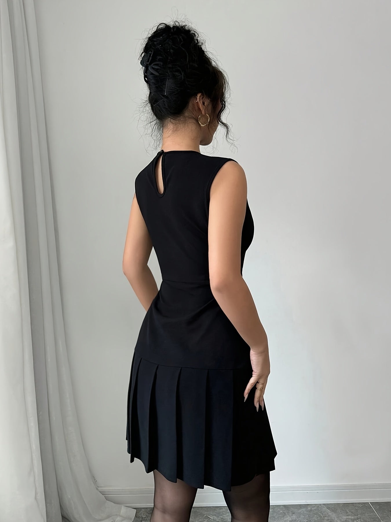 A Black Sleeveless Solid Color Ruffled Mini Dress for Women, Perfect for Birthdays, Parties, And Cocktail Events.