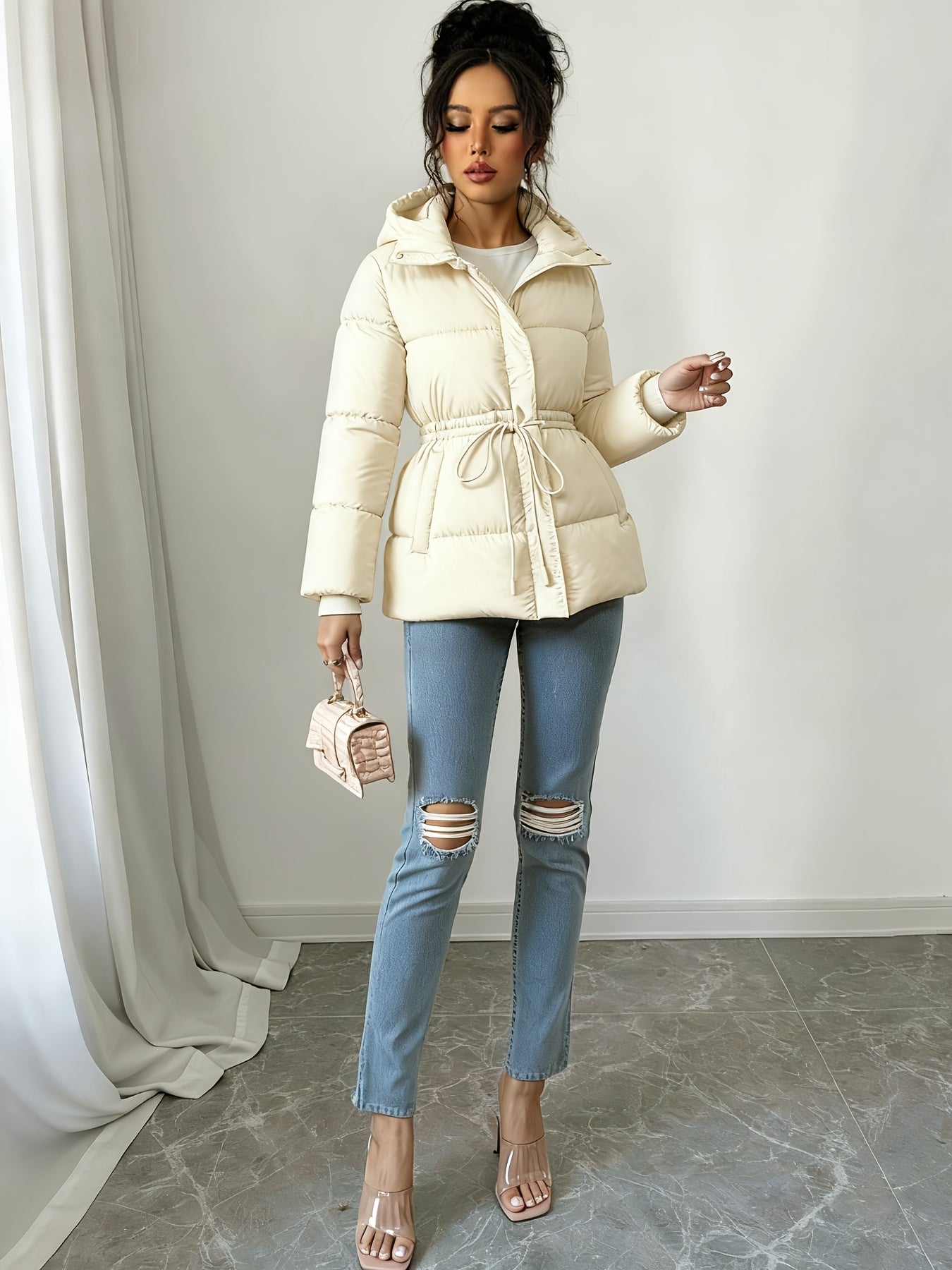 Կանացի էլեգանտ սև փքված բաճկոն՝ միջին երկարության, ազատ չափսերով, կարգավորվող լարով գոտկատեղով, երկար թևքերով և առջևի կայծակաճարմանդով, առօրյա ձմեռային վերնազգեստ ցուրտ եղանակի համար, ձմեռային բաճկոն