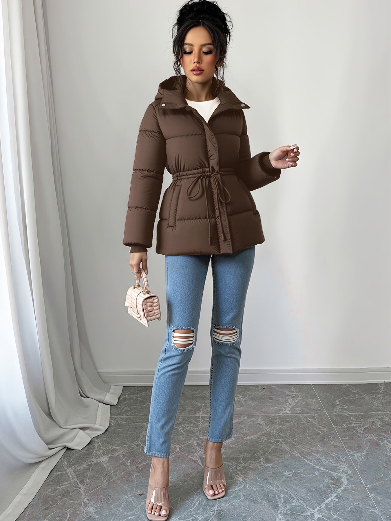 Կանացի էլեգանտ սև փքված բաճկոն՝ միջին երկարության, ազատ չափսերով, կարգավորվող լարով գոտկատեղով, երկար թևքերով և առջևի կայծակաճարմանդով, առօրյա ձմեռային վերնազգեստ ցուրտ եղանակի համար, ձմեռային բաճկոն