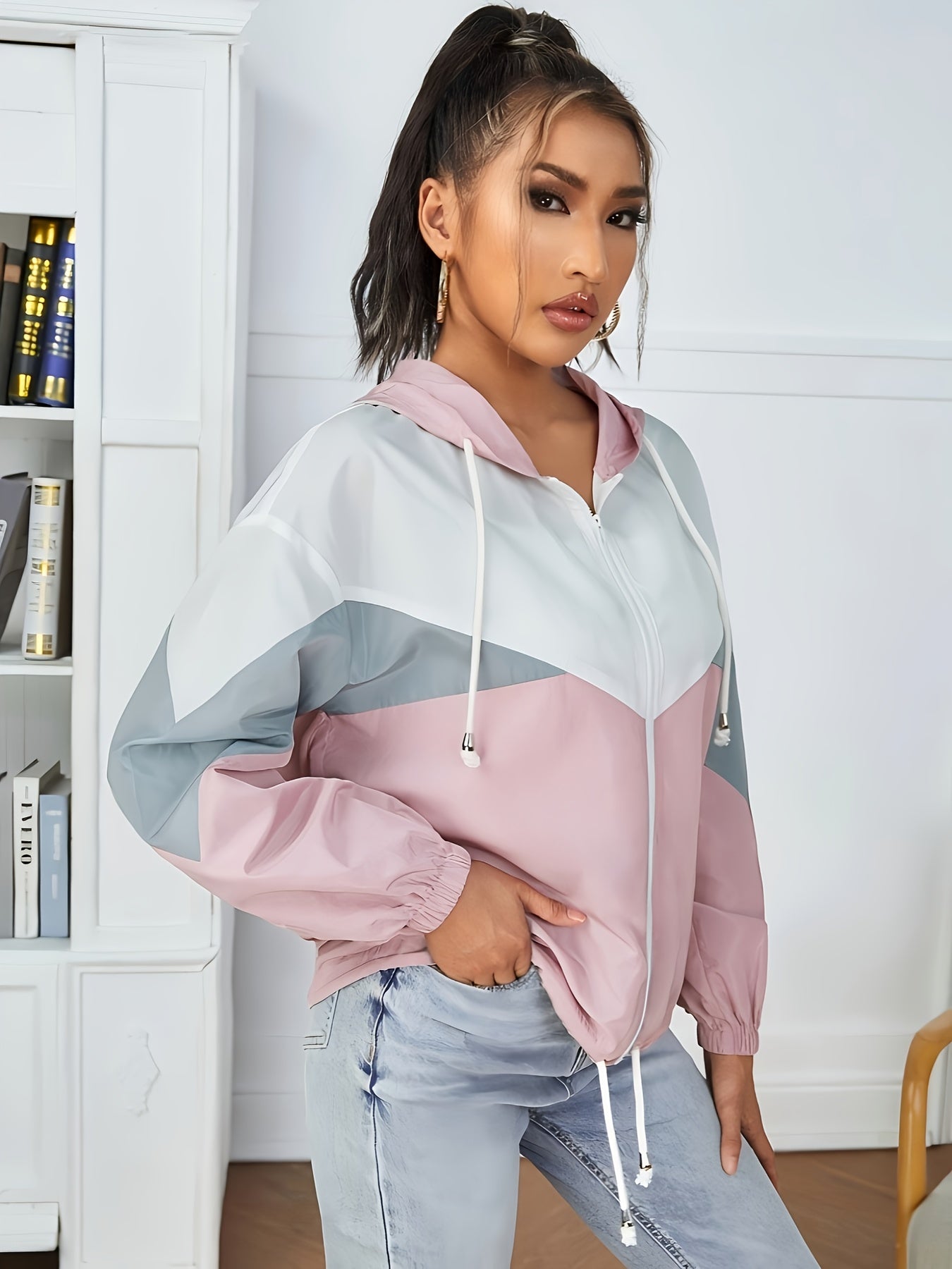 Նորաձև, ուսերը իջեցված, գլխարկով, գունային բլոկներով արևապաշտպան բաճկոն՝ կայծակաճարմանդով և լարով