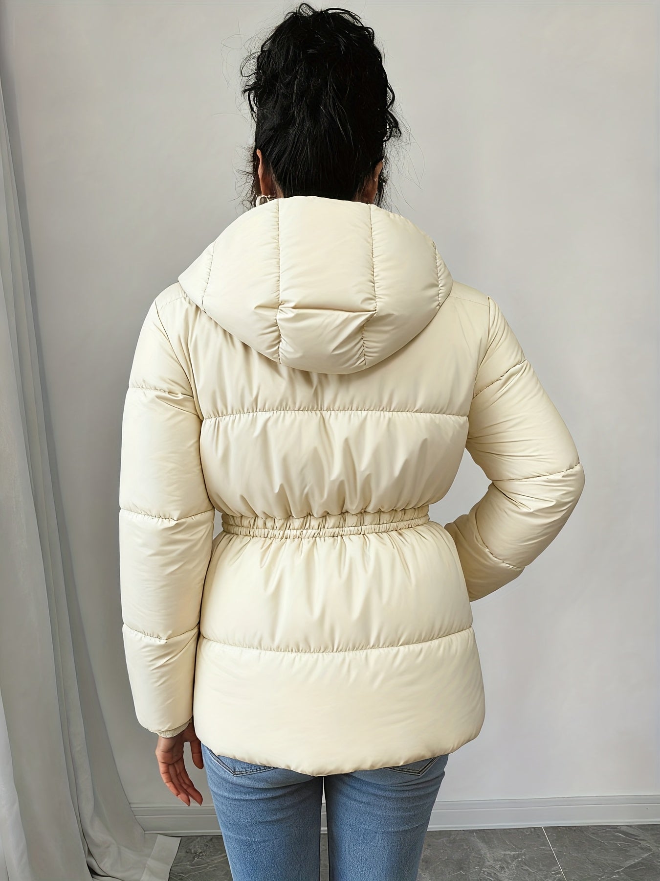 Կանացի էլեգանտ սև փքված բաճկոն՝ միջին երկարության, ազատ չափսերով, կարգավորվող լարով գոտկատեղով, երկար թևքերով և առջևի կայծակաճարմանդով, առօրյա ձմեռային վերնազգեստ ցուրտ եղանակի համար, ձմեռային բաճկոն